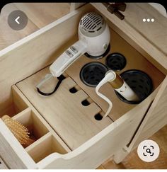 an electric hair dryer is sitting in a drawer with other items on the drawers