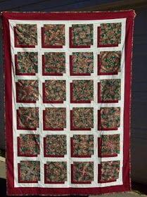 a red and white quilt hanging on the side of a building