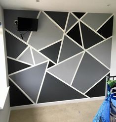 an empty room with black and white wallpaper on the walls, in front of a flat screen tv