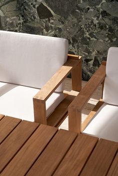 two white chairs sitting next to each other on top of a wooden floor covered in rocks