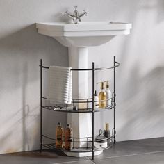 a white sink sitting next to a metal rack with soaps and lotions on it