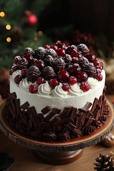 a cake with white frosting and cranberry toppings on a wooden platter