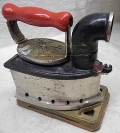 an old fashioned stove with a red handle