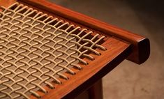 a close up of a wooden chair with woven fabric on it