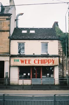 an old building with a sign that says the wee chippy