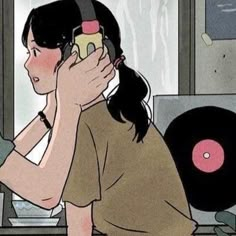 a woman is listening to music with headphones on her ears while sitting in front of a record player