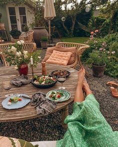 a person sitting at a table with food on it and an umbrella in the background