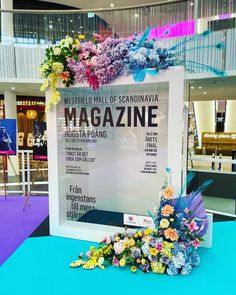 a sign with flowers on it sitting in front of a blue and purple carpeted floor