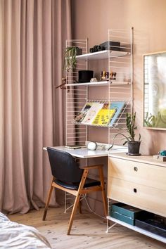 a room with a desk, chair and shelves on the wall next to a window