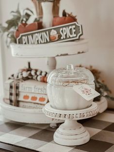 two white pumpkins sitting on top of a cake stand