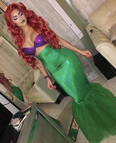 a woman with red hair wearing a green mermaid costume