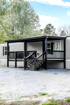 a mobile home with stairs leading up to the front door and second story porch area