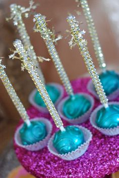 there are cupcakes with blue frosting and sparkle sticks on top of them