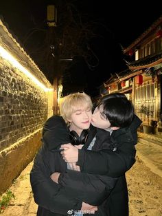 two young men hugging each other in the street