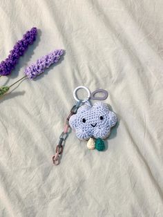 a crocheted keychain with a stuffed animal on it next to lavender flowers