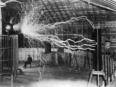 a man sitting on a bench in front of a lightening machine