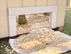 a pile of wood shaving next to a building