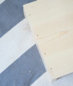 a piece of wood sitting on top of a blue and white checkered rug