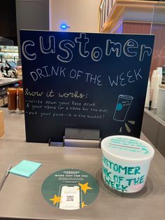 a sign that says customer drink of the week next to a bucket of ice cream