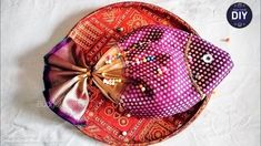 an orange and pink hat on top of a red plate with a bow tie around it