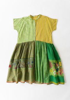 the dress is green, yellow and white with an elephant on it's chest