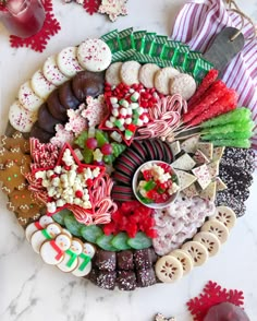 a platter filled with lots of different types of candy and cookies on top of a table