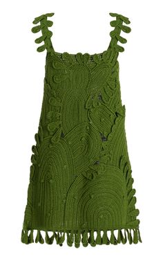 a green dress with fringes on the bottom and an openwork design at the back