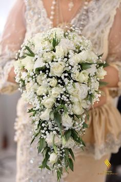 a bride holding a bouquet of white flowers