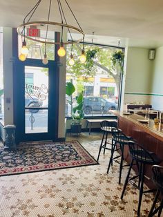 the inside of a restaurant with lots of tables and stools in front of it