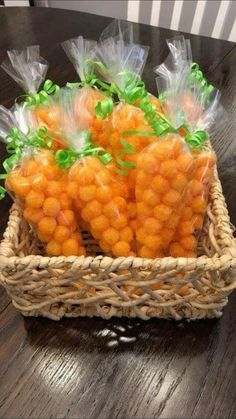 some carrots wrapped in plastic sitting on a table next to a basket with green ribbon