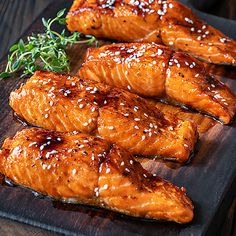 salmon fillets with sesame seeds on a wooden cutting board, ready to be served