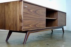 a wooden cabinet sitting on top of a cement floor