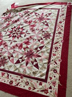 a red and white quilt is laying on the floor