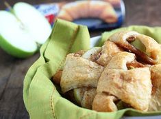 a bowl filled with apple pies on top of a table next to an apple