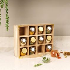 a wooden box filled with lots of different types of bottles next to plants and other items