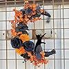 an arrangement of flowers arranged in the shape of a wreath on top of a tiled wall