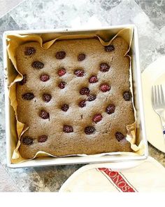 a cake in a pan with raspberries on top and a fork next to it