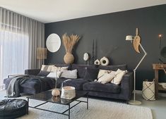 a living room filled with furniture and decor on top of a carpeted floor next to a window