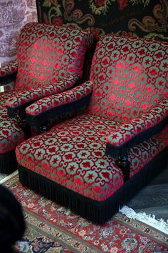 two red and black chairs sitting on top of a rug