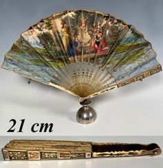 an old fan with pictures on it next to a small metal object that says 21 cm