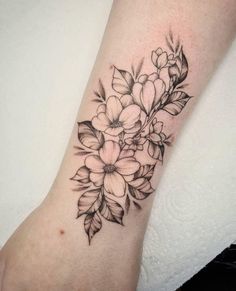 a black and white flower tattoo on the wrist