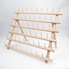 a wooden rack with several pegs attached to the top and bottom shelves on each side