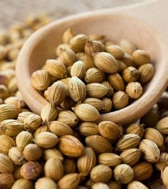 a wooden spoon filled with nuts on top of a table