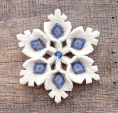 a snowflake made out of felt sitting on top of a wooden table