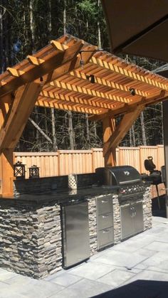 an outdoor bbq with grill and pergolated roof