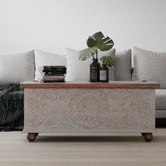 a living room with a couch, coffee table and books on the end tables in front of it