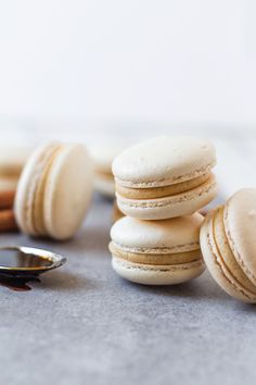 a stack of macaroons sitting on top of a table next to a spoon