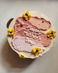 a birthday cake with pink frosting and sunflowers on the top that says happy mother's day