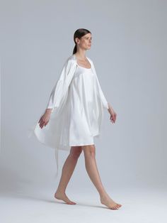 Long silk robe and nightgown set 'Meteya&Aphrodite' in milk white is designed for the most special moments of your life. The delicate silhouette of the midi dress 'Aphrodite' with a flare design and adjustable straps for a customizable fit has an elegant and feminine look that captivates with every step. The set comes with a collarless silk robe 'Meteya' with pockets for an added touch of practicality. The robe's belt has feather accents that provide a subtle yet luxurious detail that elevates t Elegant Silk Nightgown For Spring, Elegant Spring Silk Nightgown, Elegant Cream Nightgown For Spring, Elegant Summer Sleep Robe, Elegant Cream Summer Nightgown, White Silk Wedding Nightgown, Silk Nightgown For Summer Wedding, Elegant Night Robe For Spring, Elegant Spring Night Robe