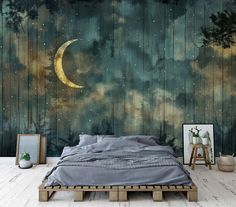 a bed sitting under a painting on the side of a wall next to a night sky